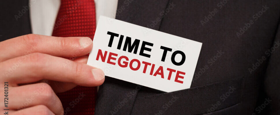 Businessman putting a card with text Time to negotiate in the pocket